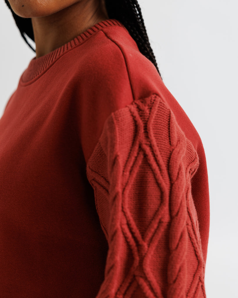 Close-up of a red sweater with intricate pattern on a plain background