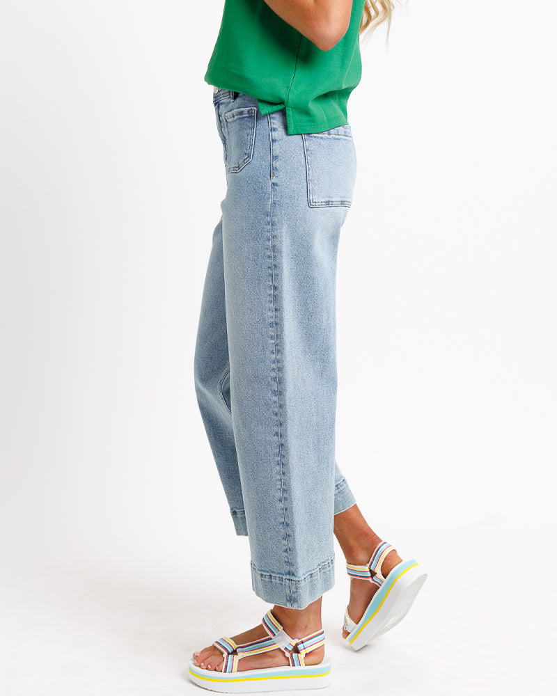 Model wearing blue wide leg, cropped, light blue denim jeans.
