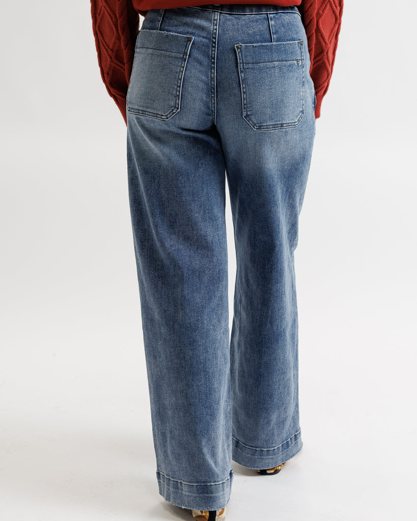 Blue jeans worn by a person on a white background