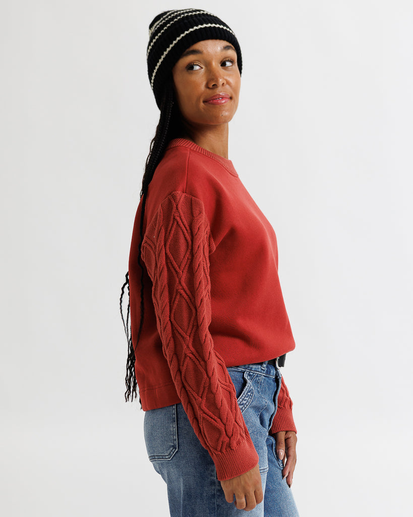 Person wearing a red sweater and black beanie with white pattern on a white background