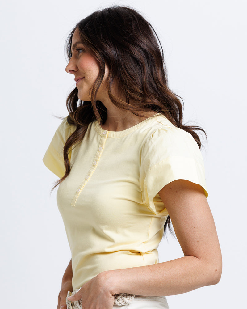 Model wearing a yellow short flutter sleeve round neck henley top