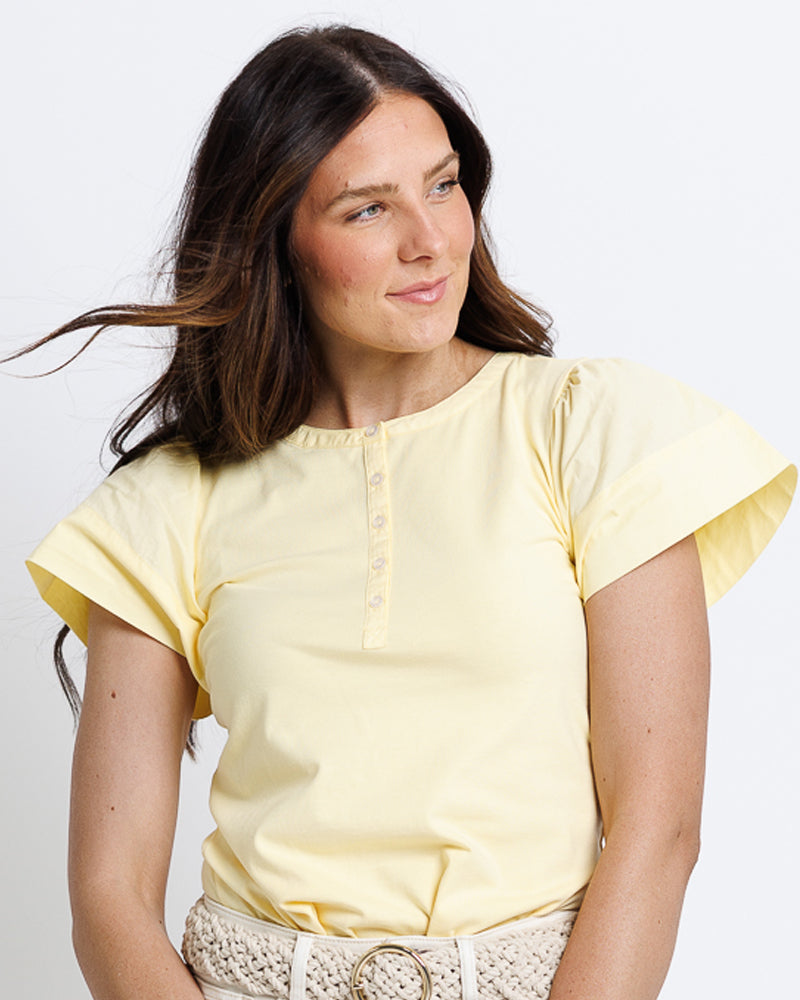 Model wearing a yellow short flutter sleeve round neck henley top