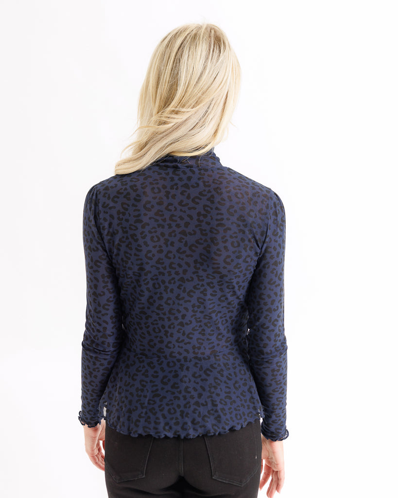 Navy blue patterned blouse worn by a person on a white background