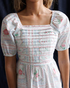 White dress with floral pattern on a plain background