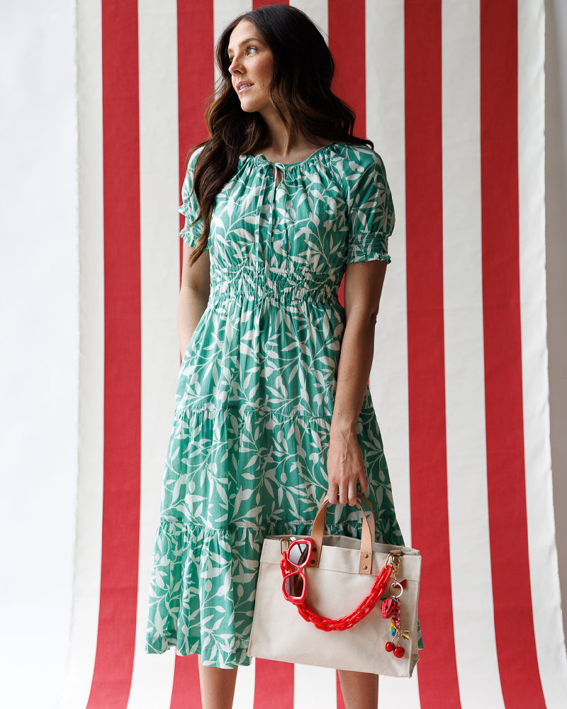 Model wearing a mint green with white floral print short sleeve round neck midi dress