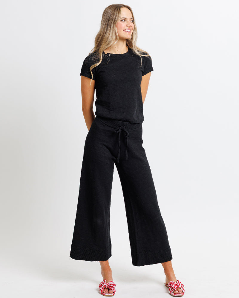 Model wearing a pair of black cropped knit pants