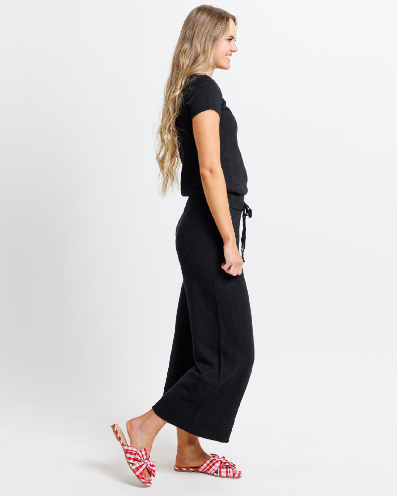 Model wearing a pair of black cropped knit pants