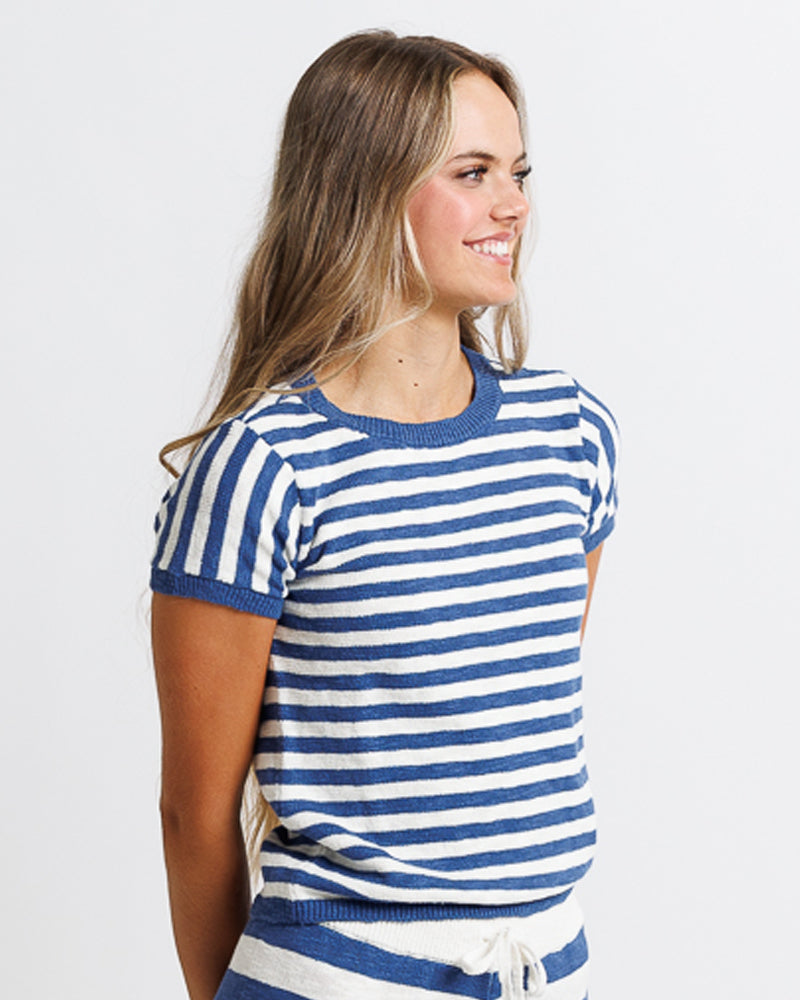 Model wearing a white and blue striped short sleeve sweater