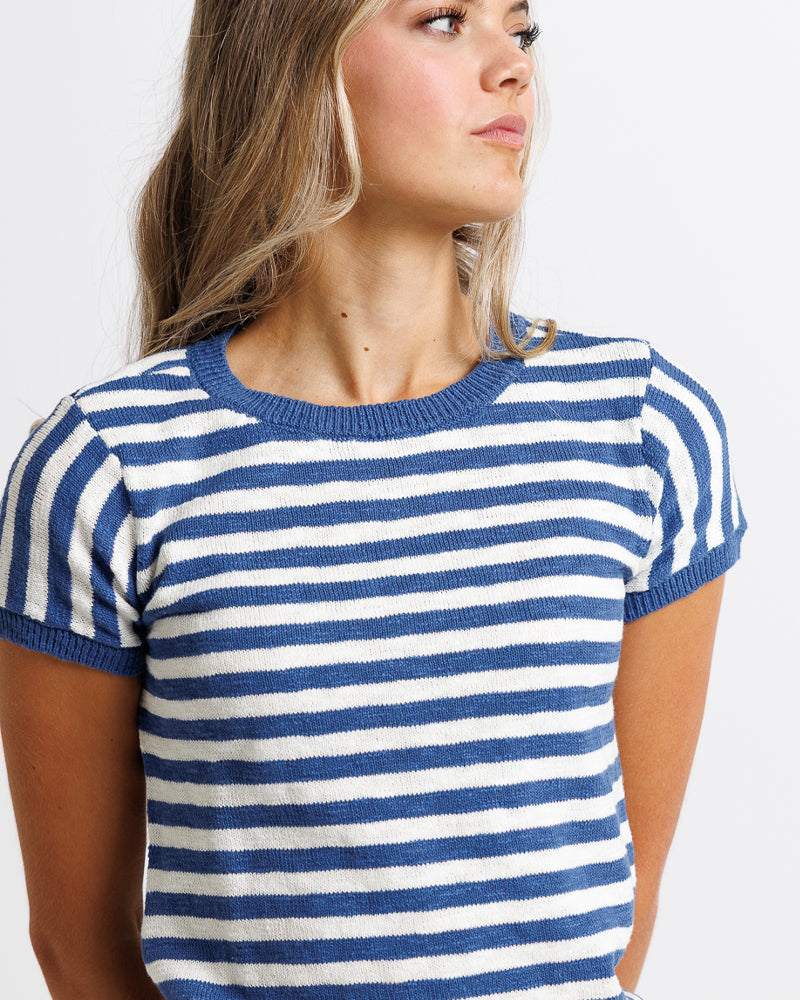 Model wearing a white and blue striped short sleeve sweater