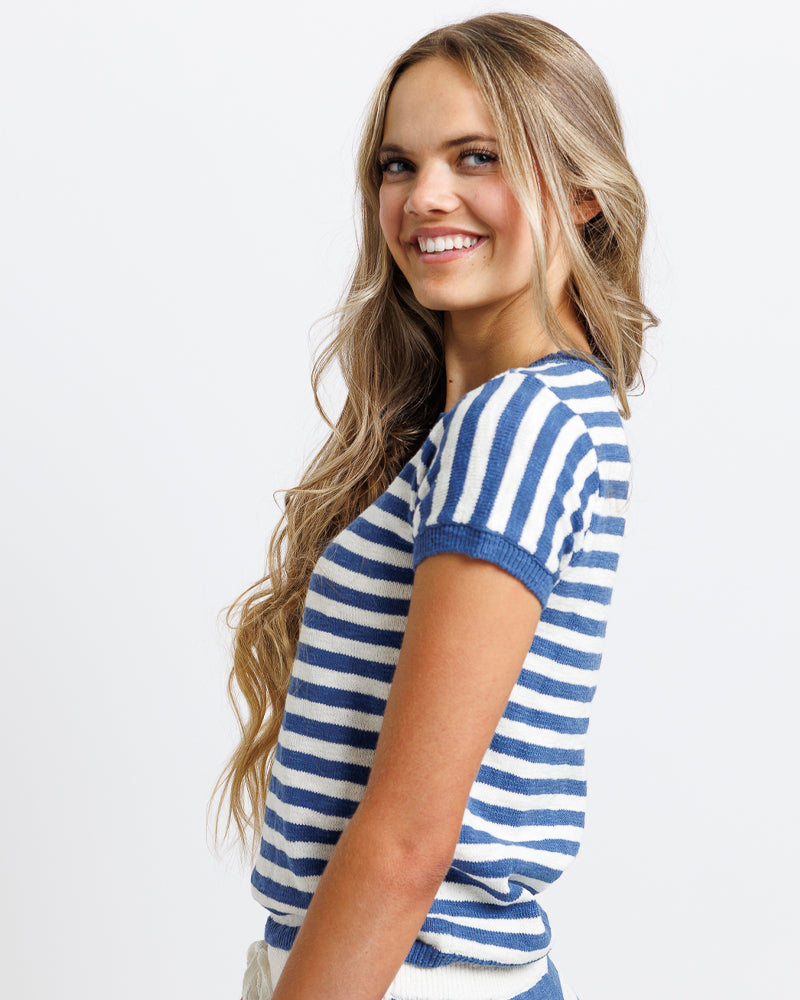 Model wearing a white and blue striped short sleeve sweater