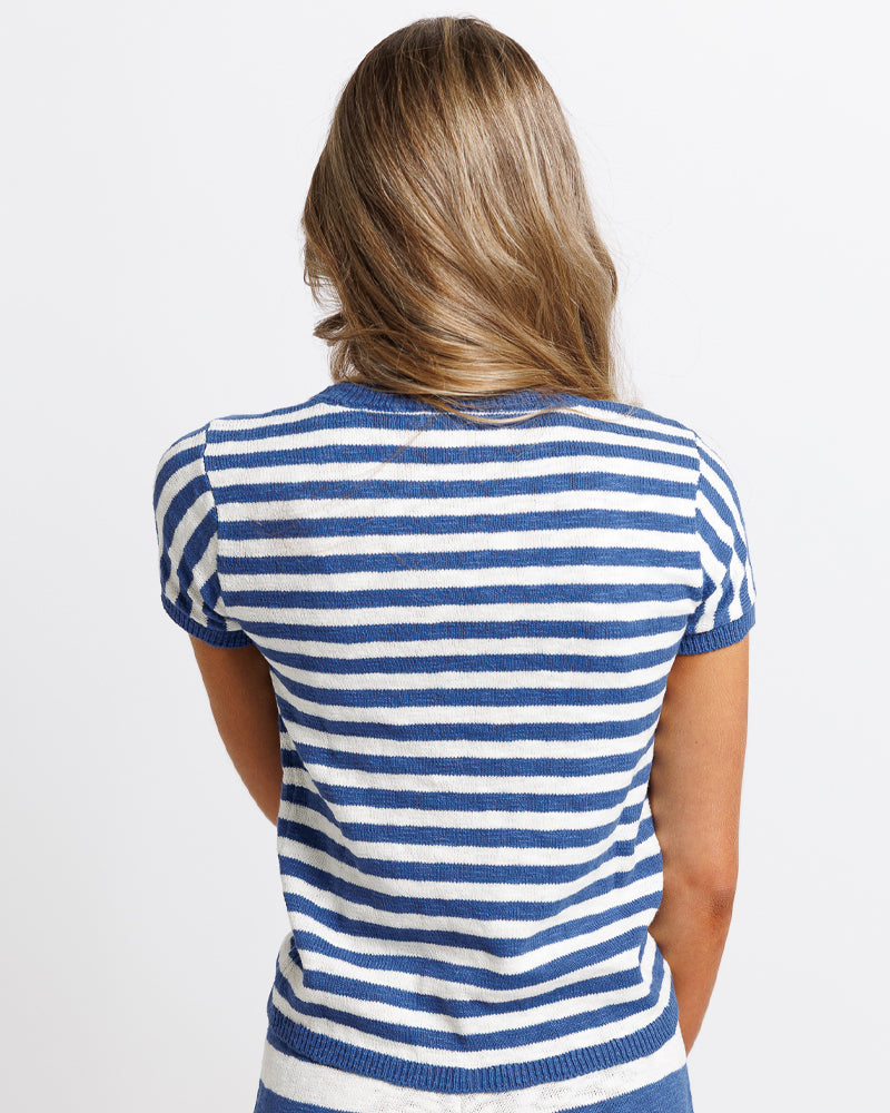 Model wearing a white and blue striped short sleeve sweater