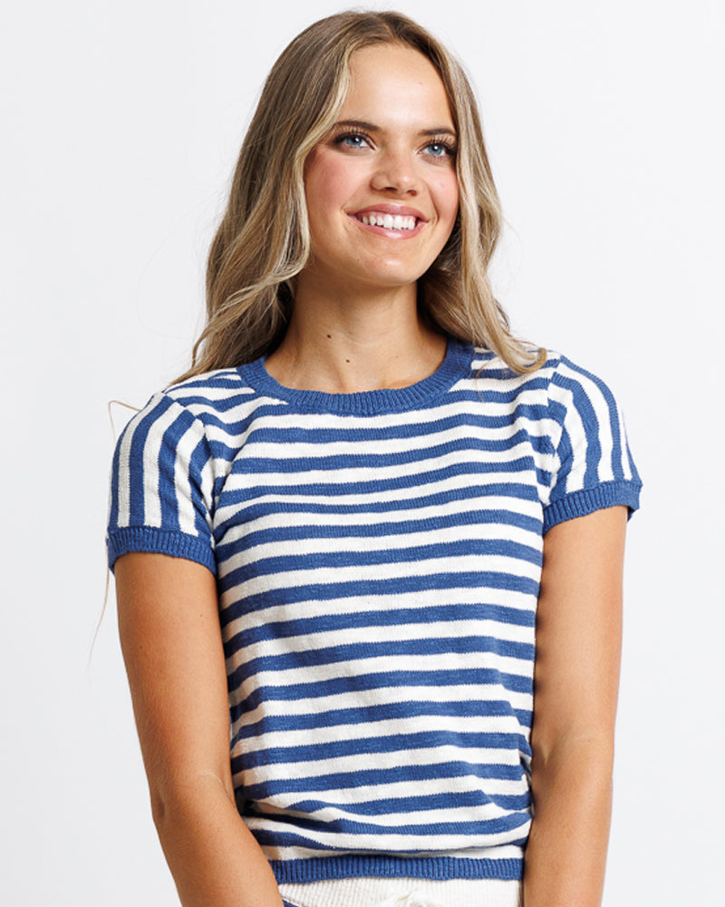 Model wearing a white and blue striped short sleeve sweater