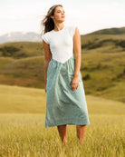 Woman wearing a white and green striped dress standing in a field