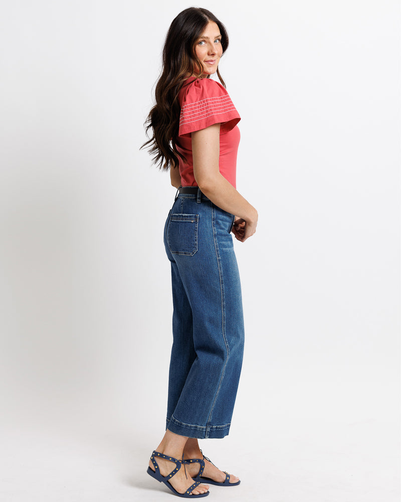 Model wearing dark blue mid-rise wide leg cropped jeans.
