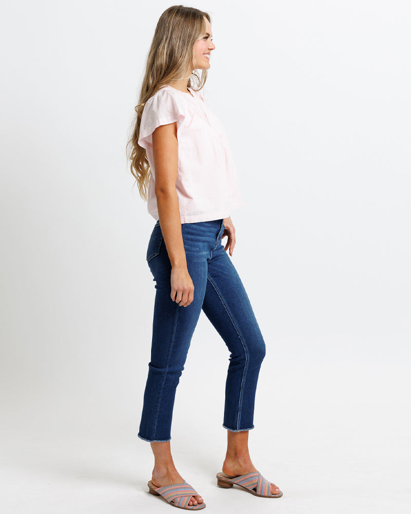 Wearing wearing dark blue high rise cropped stretch denim jeans.
