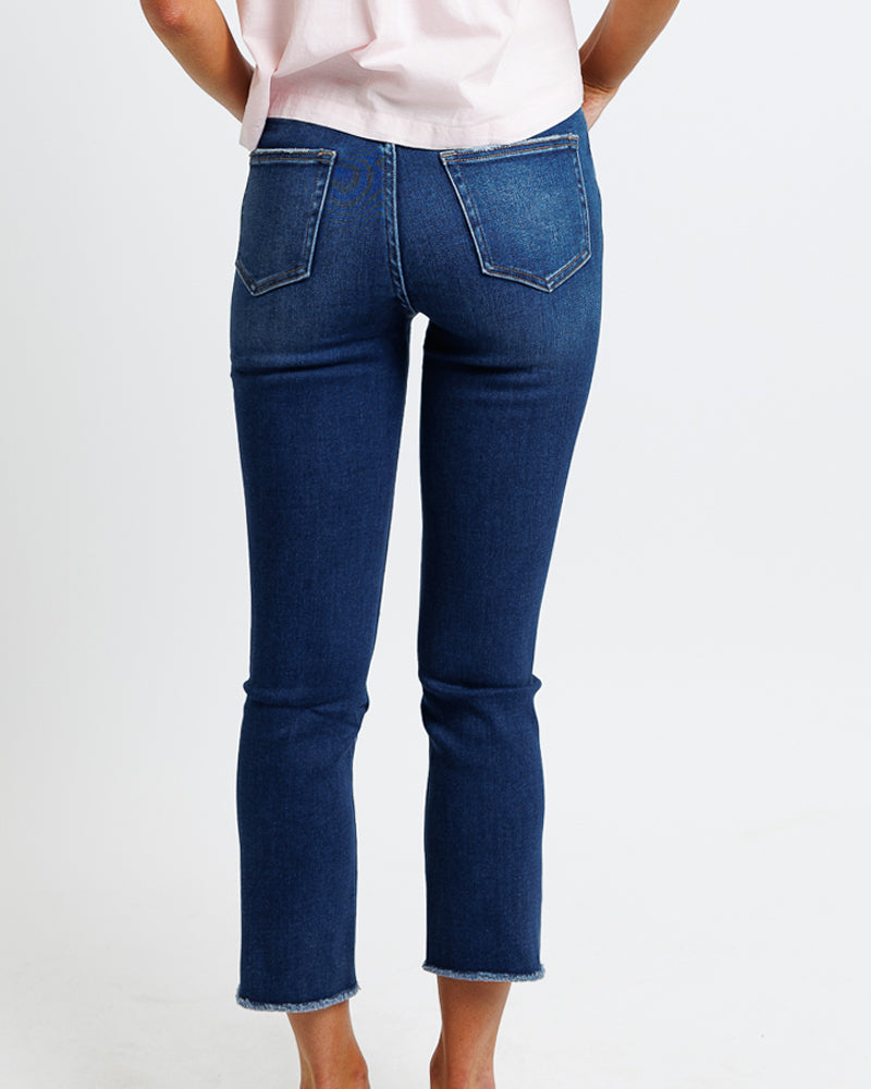 Wearing wearing dark blue high rise cropped stretch denim jeans.