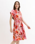 Woman wearing a pink floral dress on a white background
