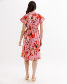 Woman wearing a pink floral dress on a white background