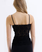Black lace top worn by a person on a white background
