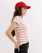 Woman wearing a red cap and striped shirt on a white background