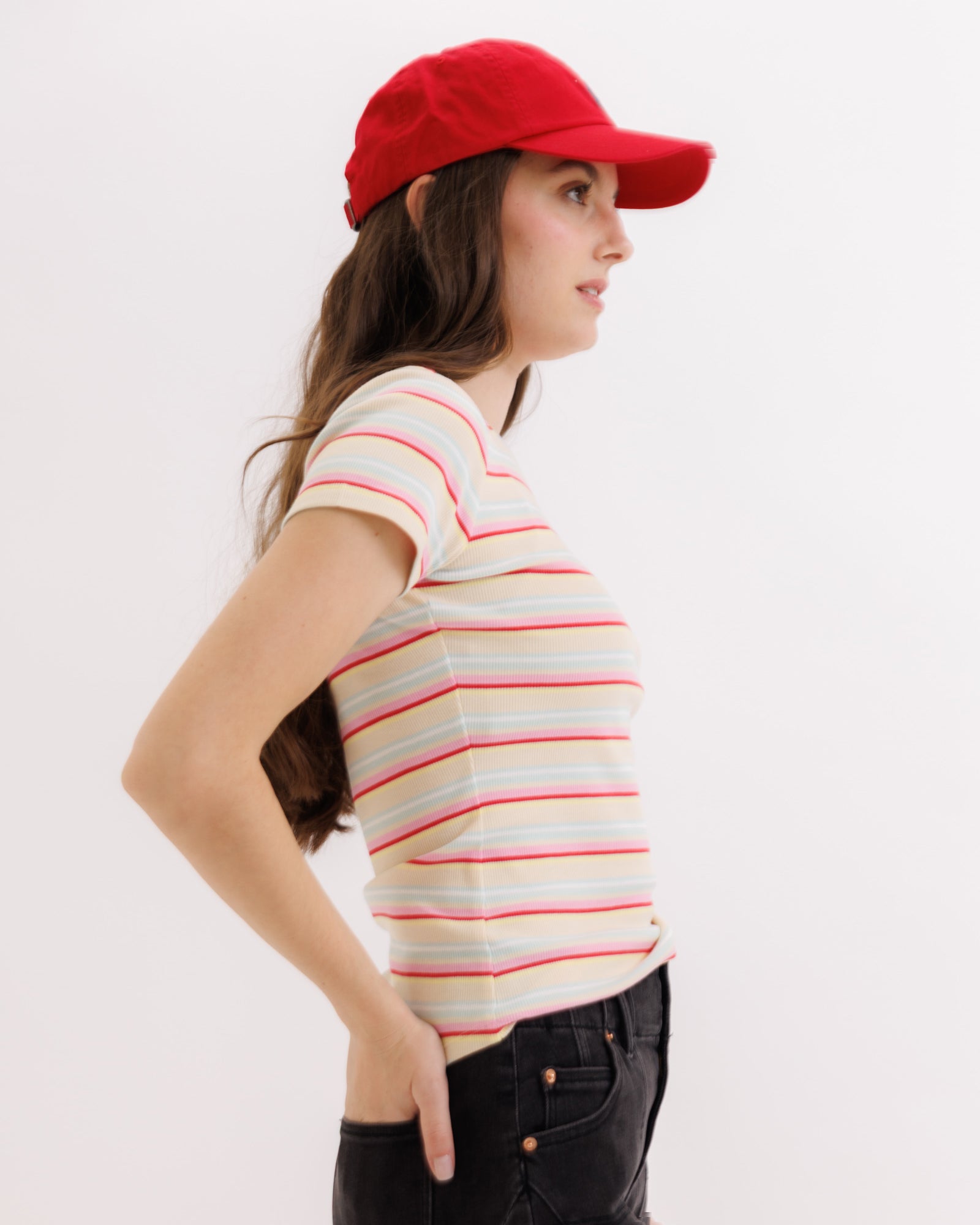 Woman wearing a red cap and striped shirt on a white background