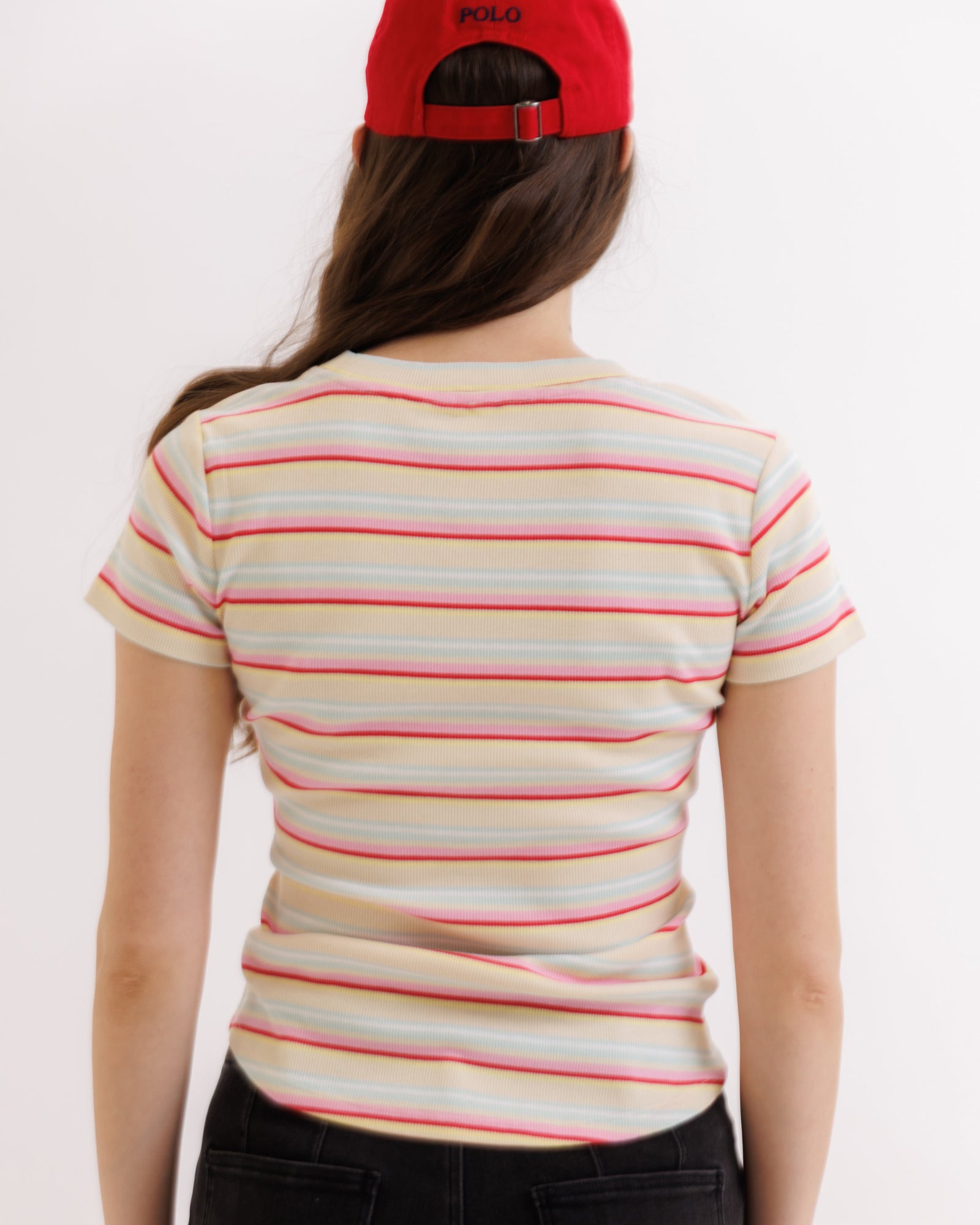 Person wearing a striped shirt and red cap on a white background