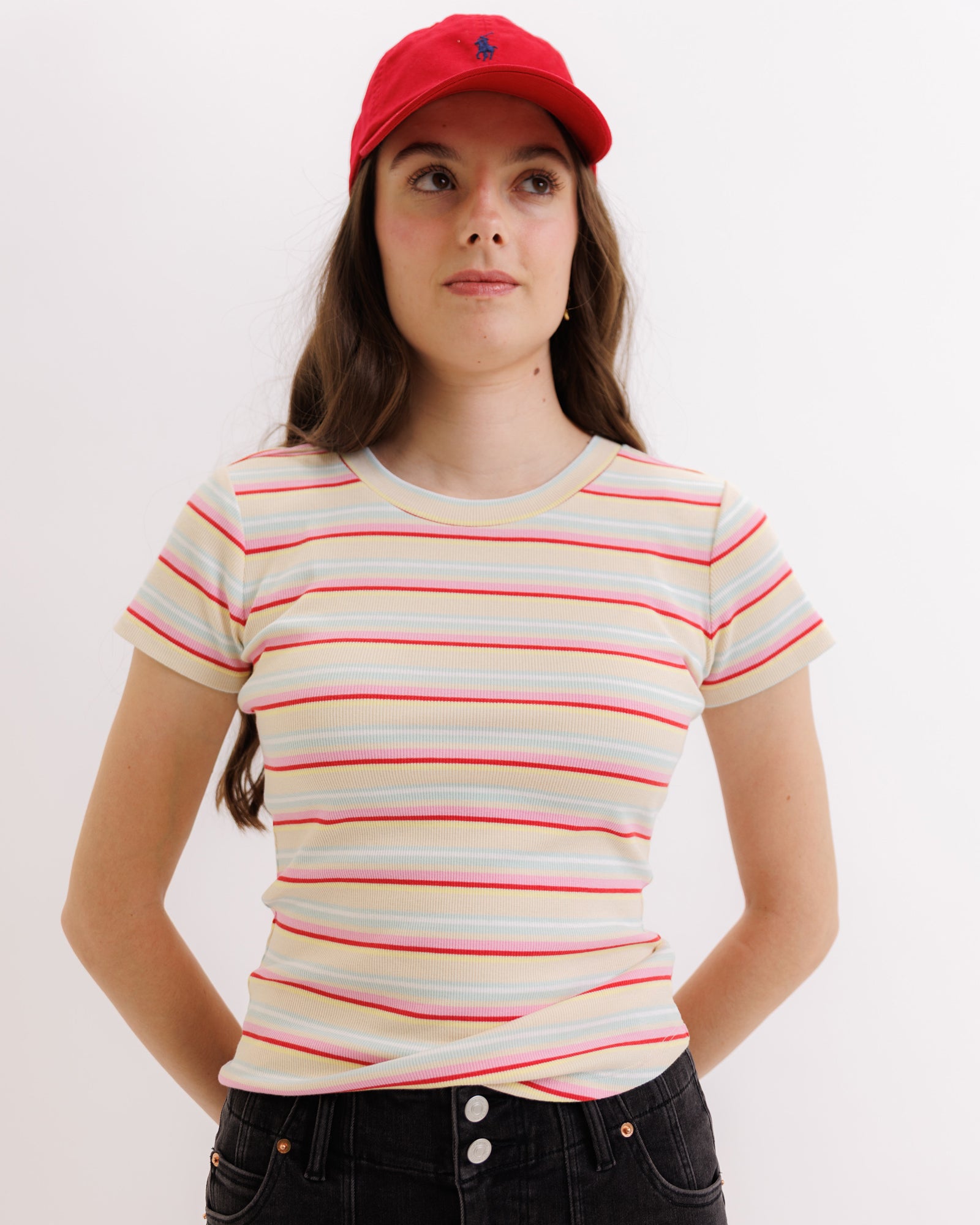 Person wearing a striped t-shirt and red cap on a white background