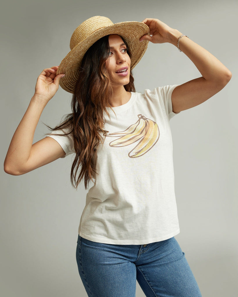 Woman in a short sleeve white graphic tee with a banana on the front