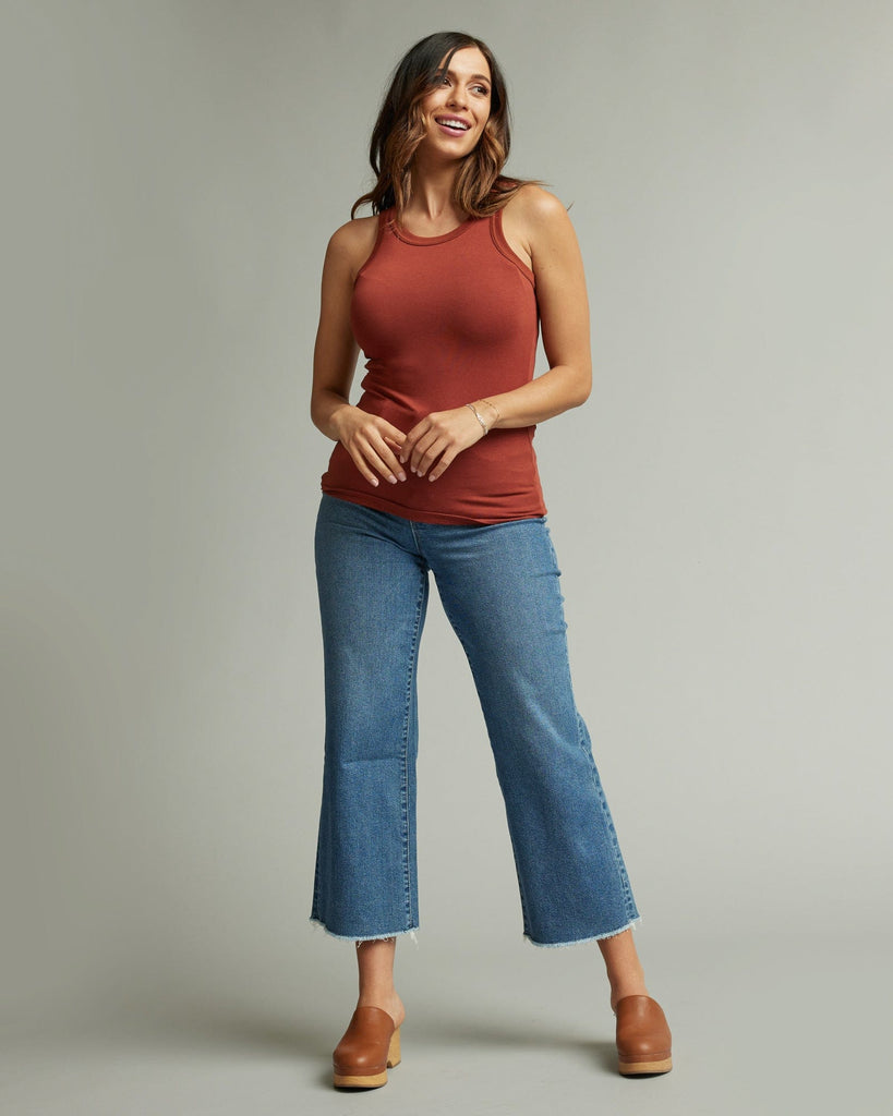 Woman in sleeveless, fitted, high neck, basic tank top