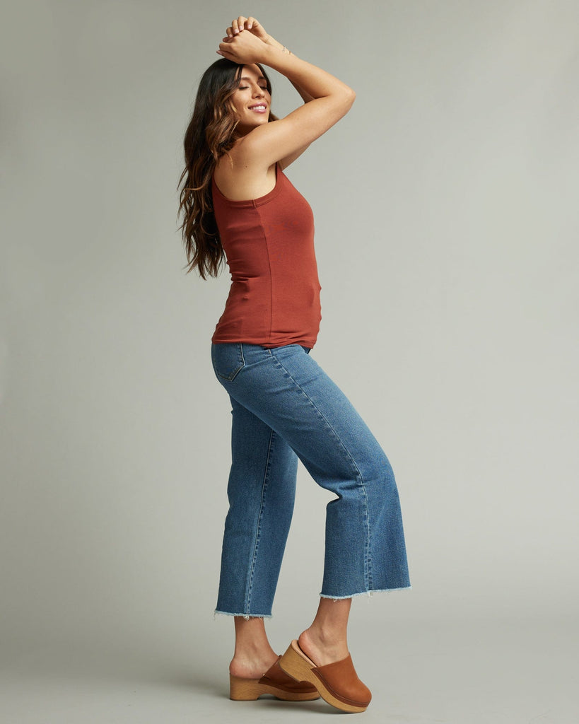 Woman in sleeveless, fitted, high neck, basic tank top