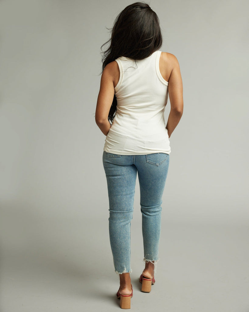 Woman in sleeveless, fitted, high neck, basic tank top