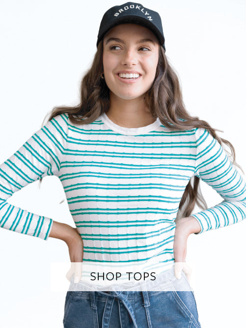 Woman wearing a striped shirt and cap with 'Brooklyn' text, on a white background.