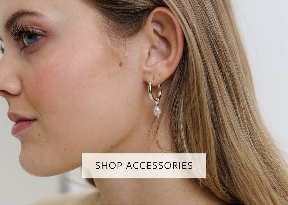 Close-up of a woman wearing earrings with a 'Shop Accessories' text overlay.