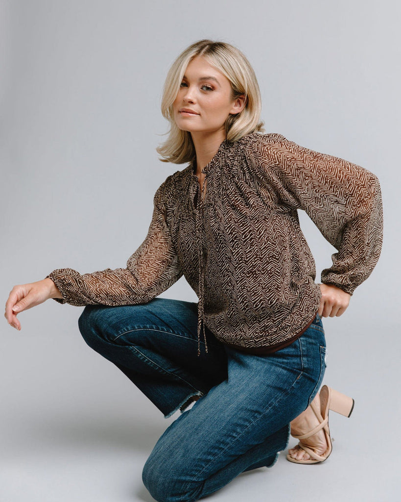 Woman in a long sleeve, chevron printed blouse