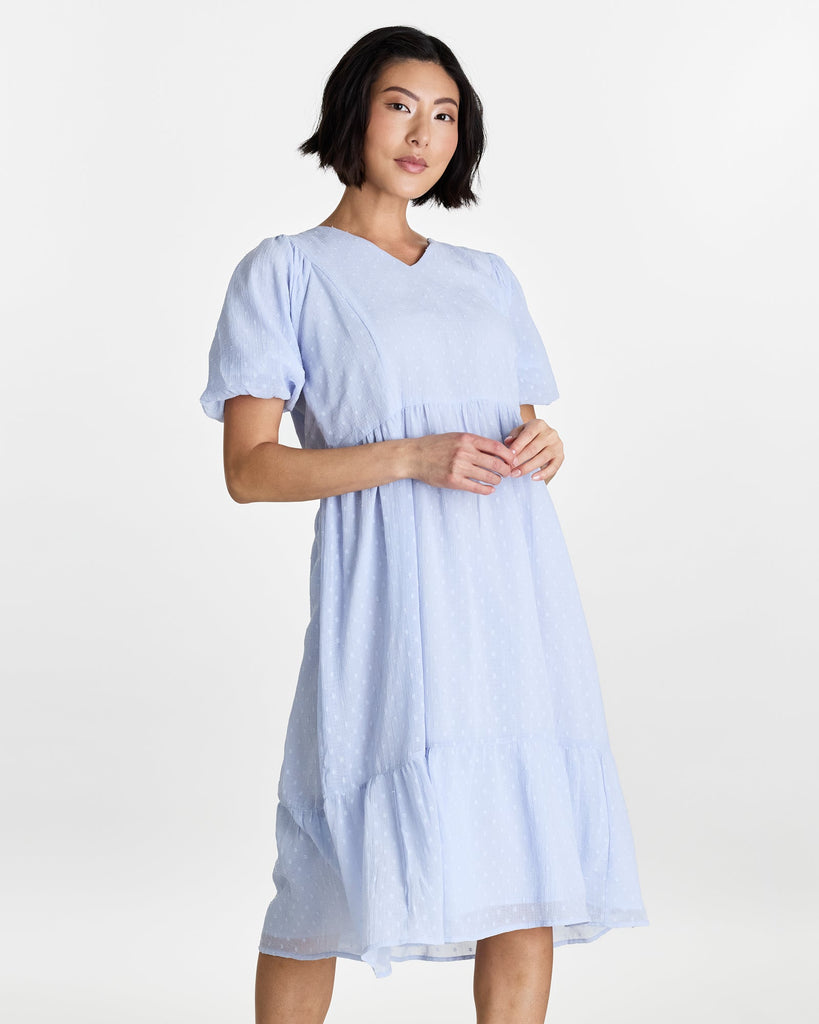 Woman in a short puffed sleeve, v-neck, midi length dress