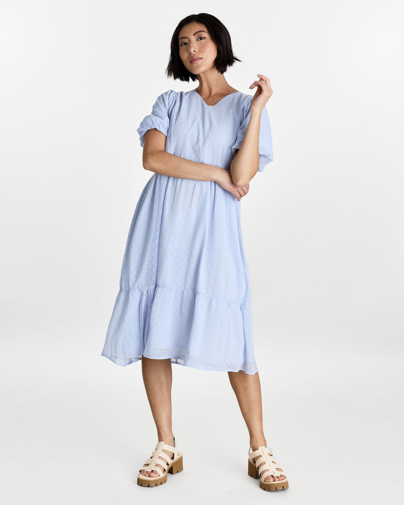 Woman in a short puffed sleeve, v-neck, midi length dress