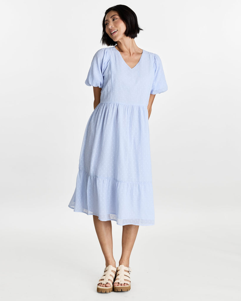 Woman in a short puffed sleeve, v-neck, midi length dress