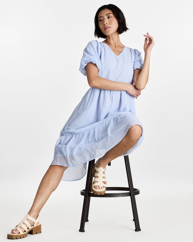 Woman in a short puffed sleeve, v-neck, midi length dress