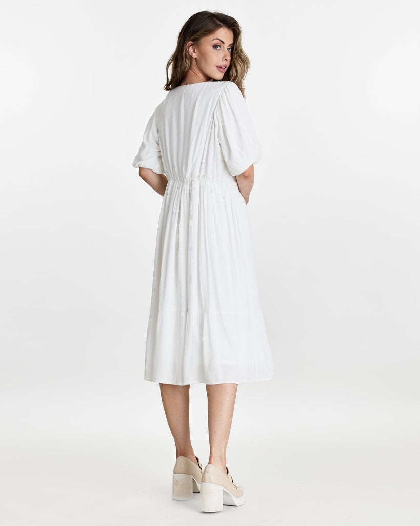 Woman in a short puffed sleeve, v-neck, midi length dress