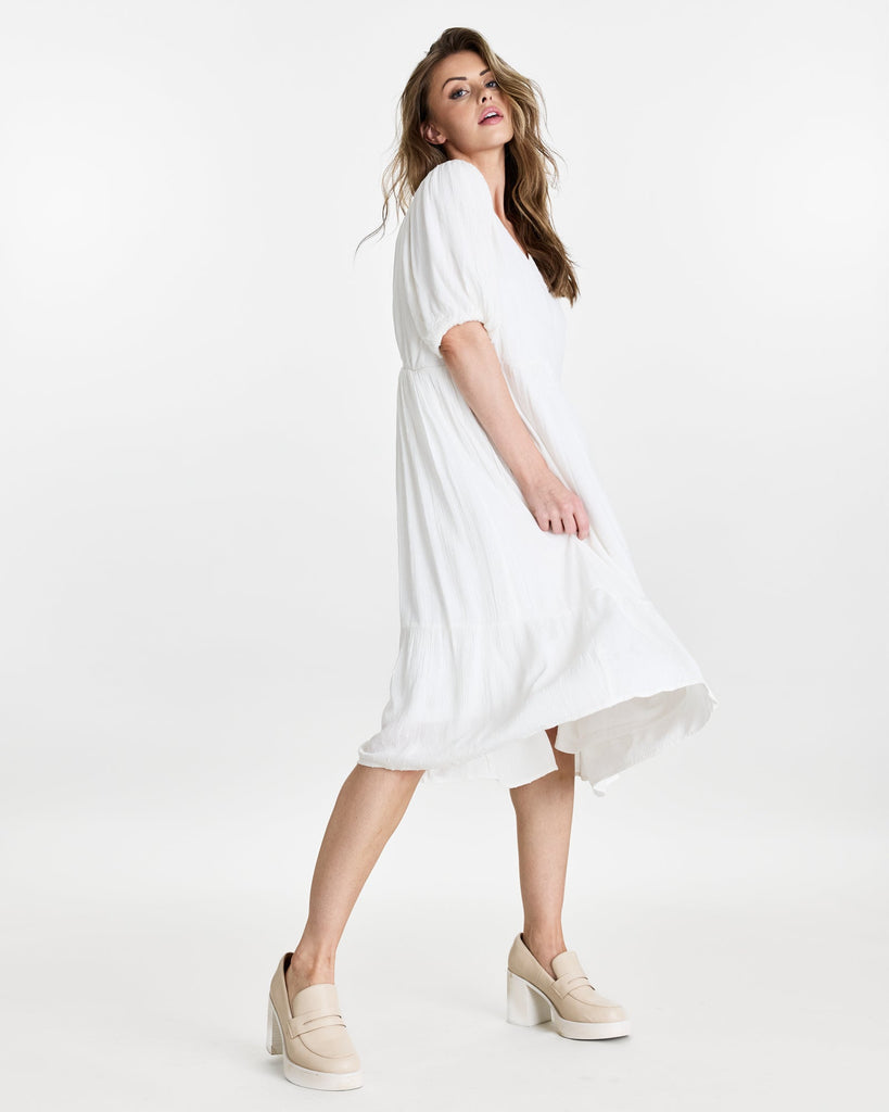 Woman in a short puffed sleeve, v-neck, midi length dress