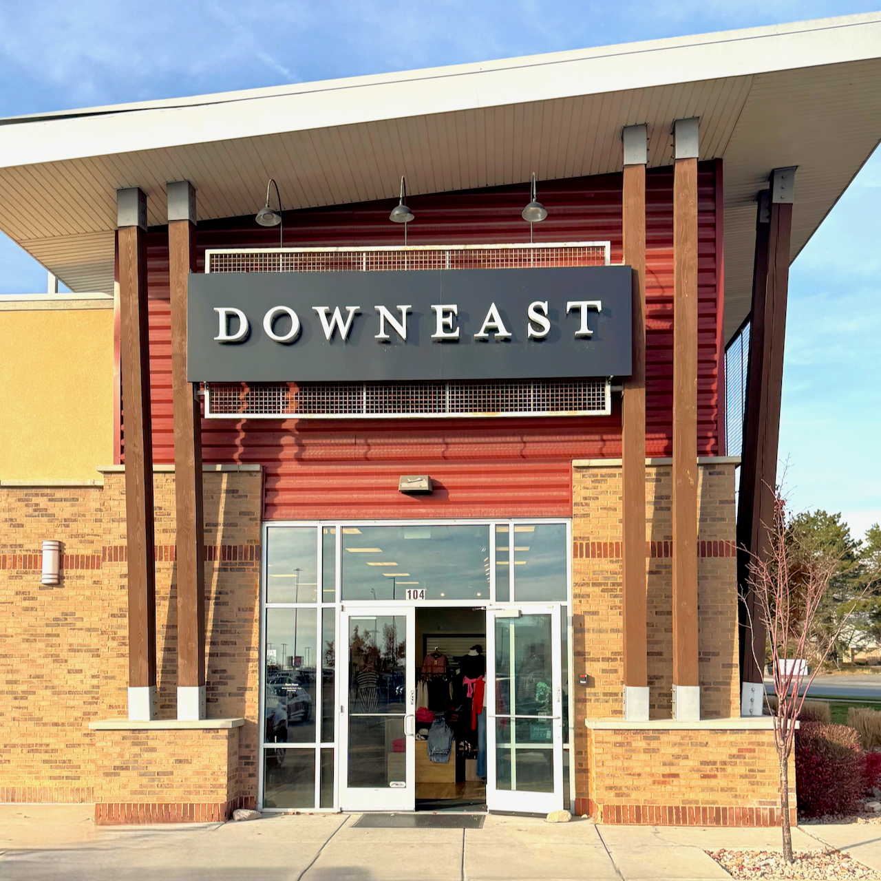 Storefront entrance with 'Downeast' sign on a clear day