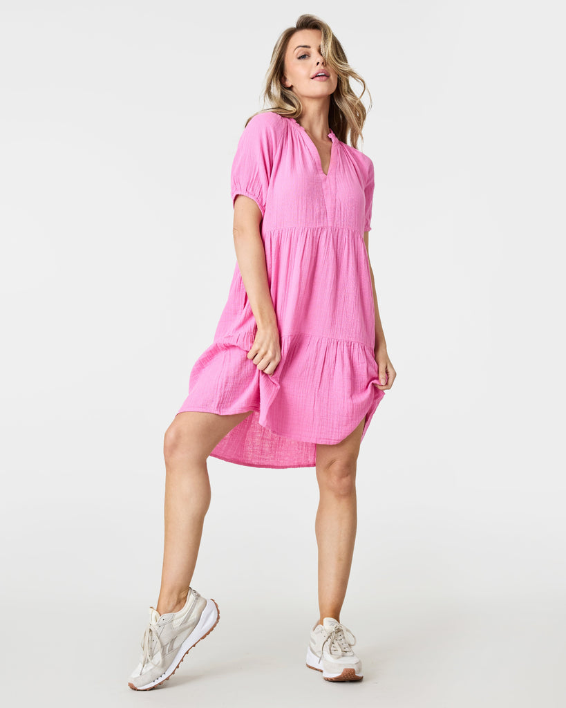 Woman in a pink short sleeve, tiered, mini-dress