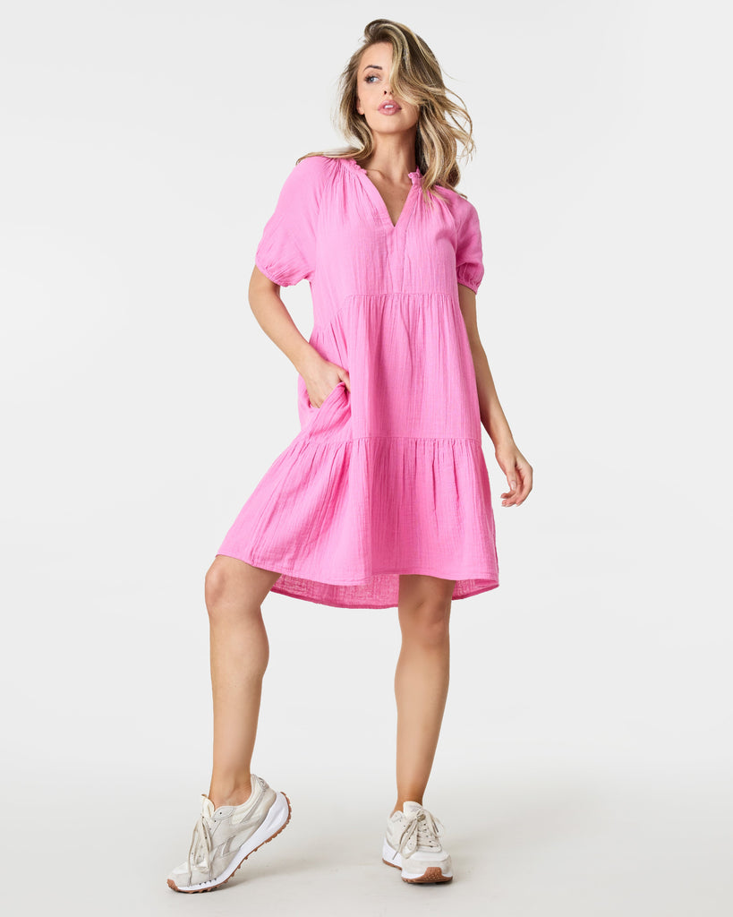 Woman in a pink short sleeve, tiered, mini-dress