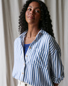 Woman wearing a blue and white striped shirt against a neutral background