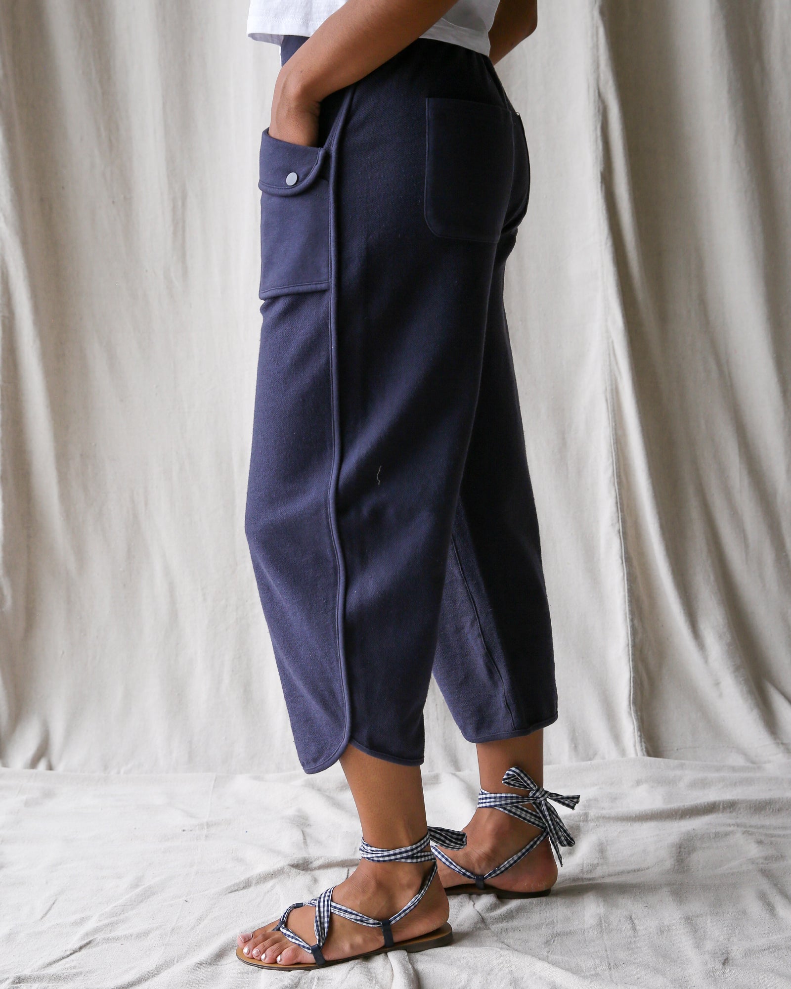 Person wearing navy blue pants with a white background