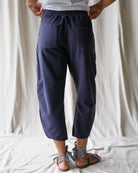Person wearing navy blue pants with a white background