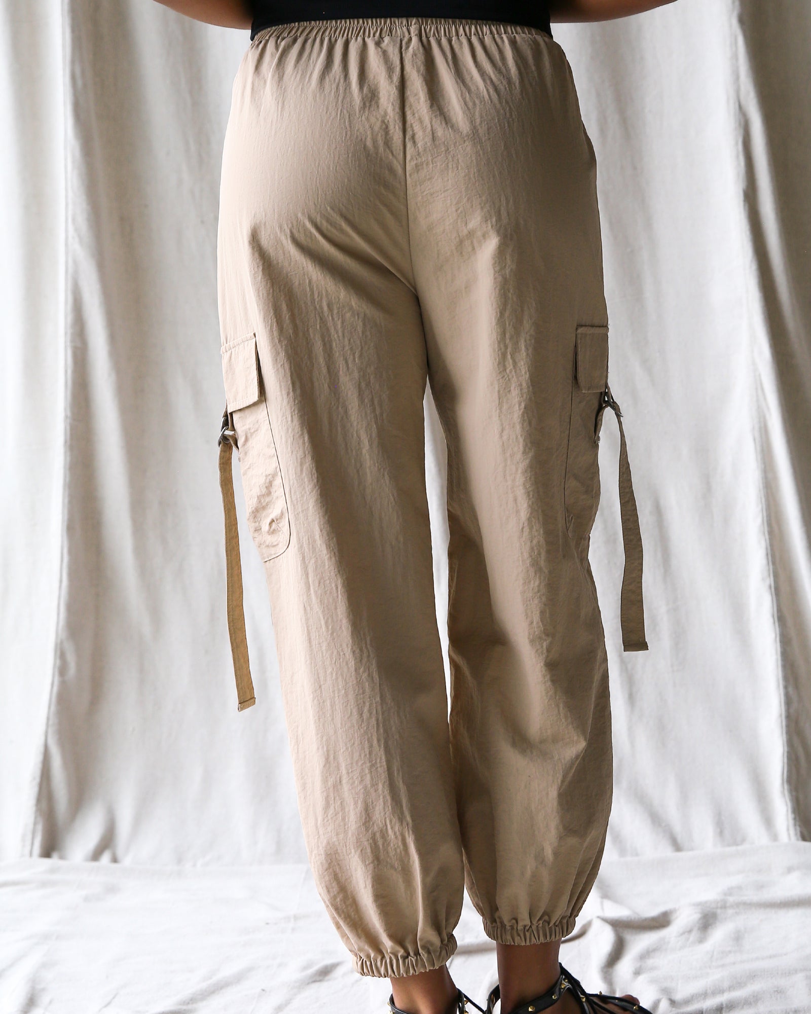 Beige cargo pants worn by a person on a white background