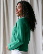 Woman wearing a green sweater against a neutral background