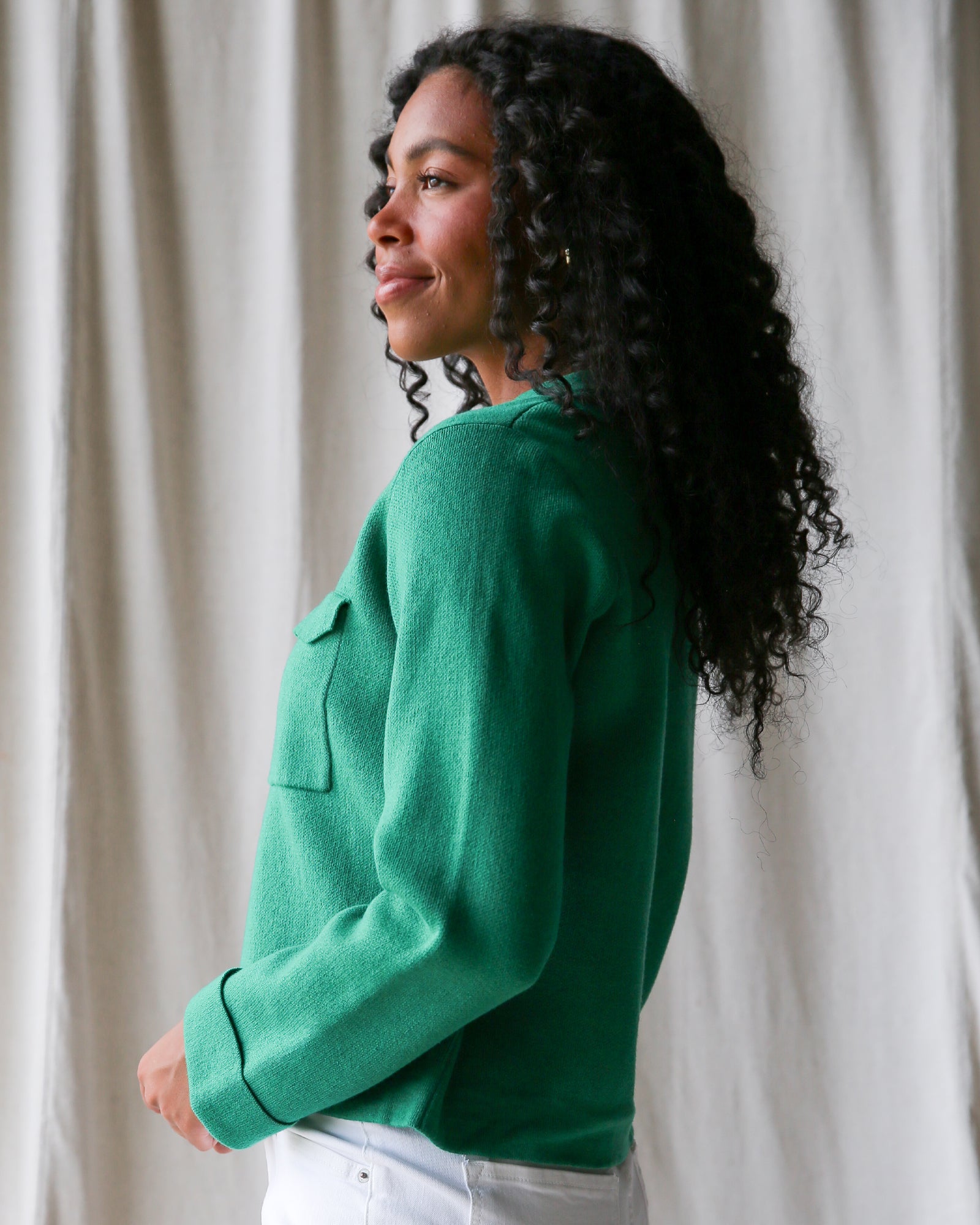 Woman wearing a green sweater against a neutral background