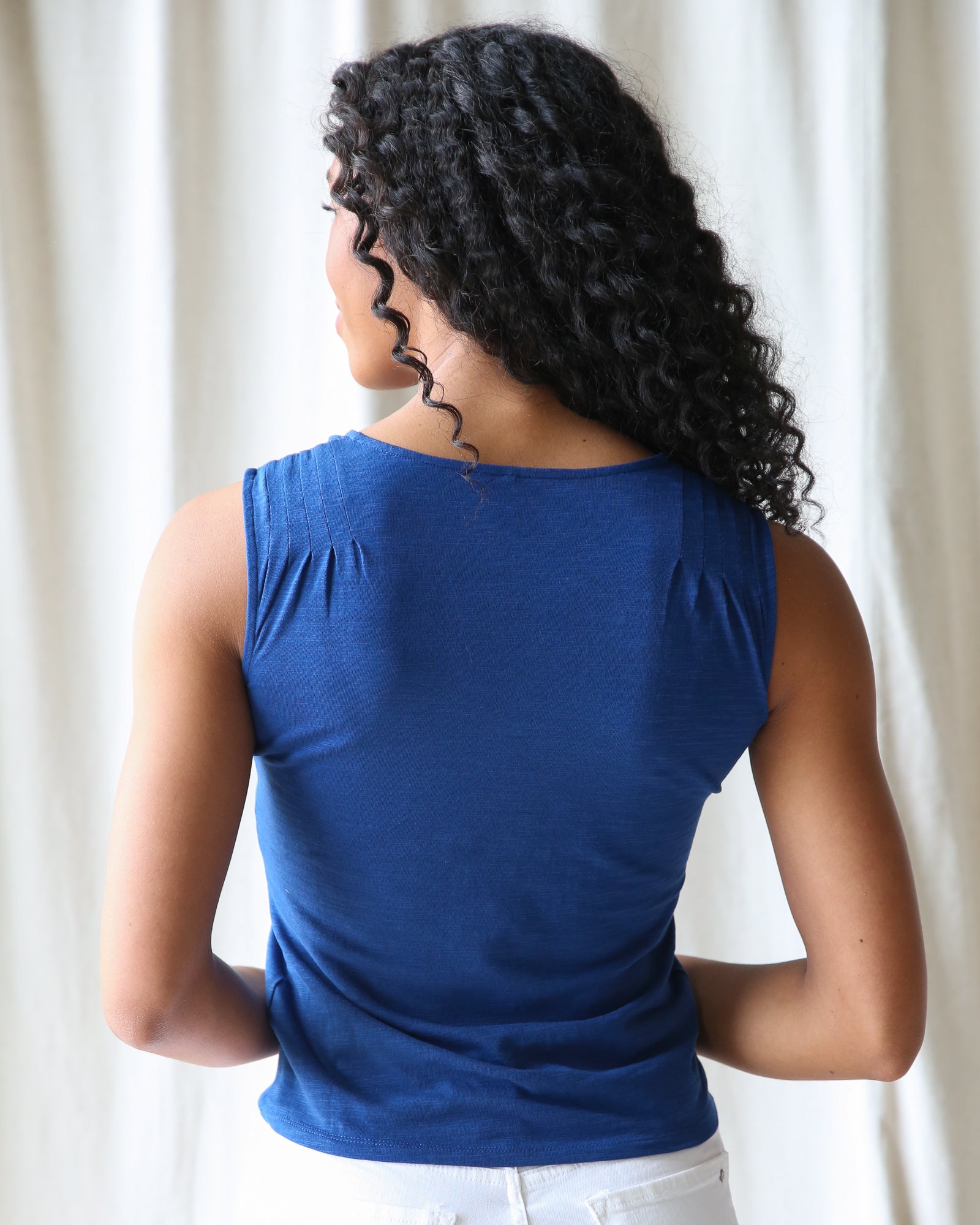 Woman wearing a blue top with a neutral background